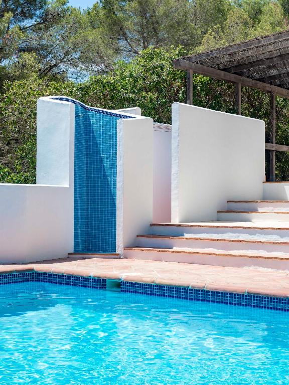 a swimming pool with stairs and a blue tile wall at Villa Tosalet Pomelo in Jávea