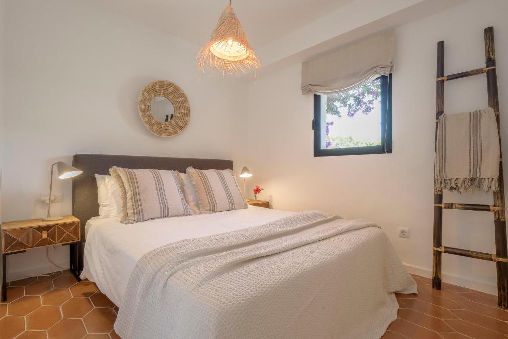 a bedroom with a white bed and a window at Villa Tosalet Pomelo in Jávea