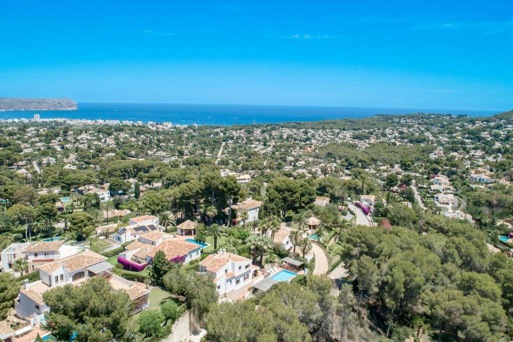 an aerial view of a house with trees and the ocean at Villa Tosalet Pomelo in Jávea