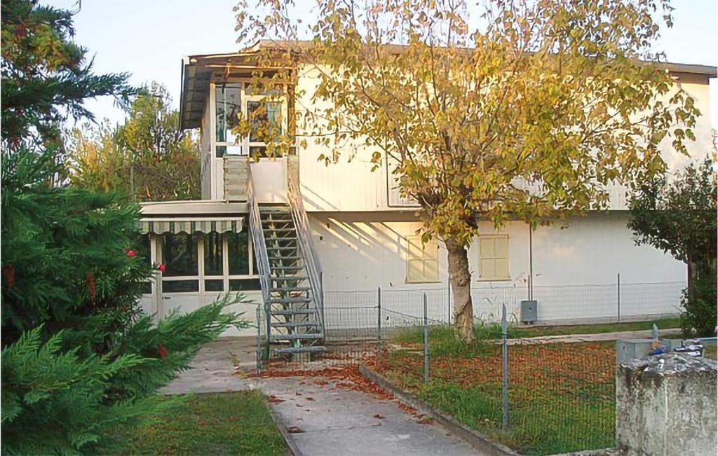 a house with a ladder in front of it at Lovely Apartment In Rosolina Mare in Rosolina Mare