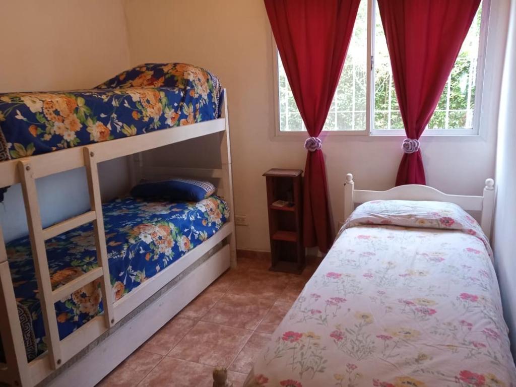 1 dormitorio con 2 literas y 1 cama pequeña en Casa Milan, en Villa General Belgrano