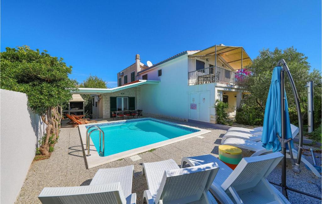 Un patio trasero con piscina y una casa. en Holiday Home Put Punte Vi, en Okrug Donji