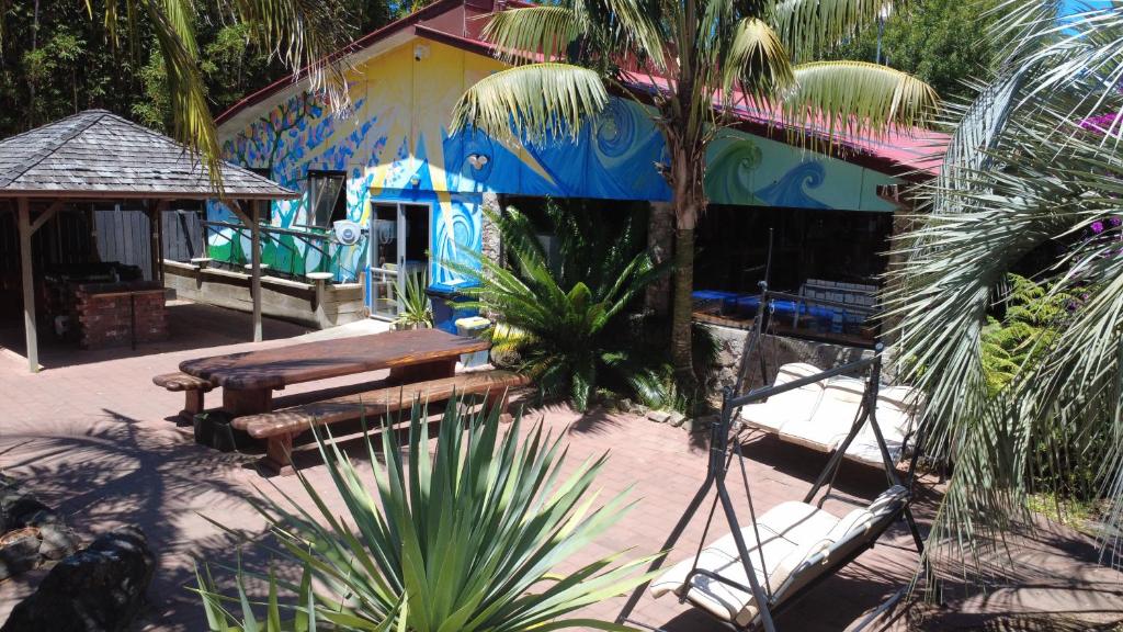 a blue building with a table and benches in front of it at Ahipara TOP 10 Holiday Park in Ahipara