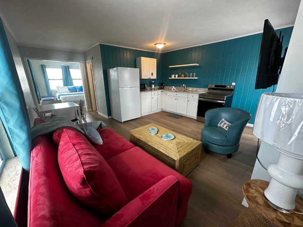 a living room with a red couch and a kitchen at Playa Esmeralda suite 3 in Bradenton Beach