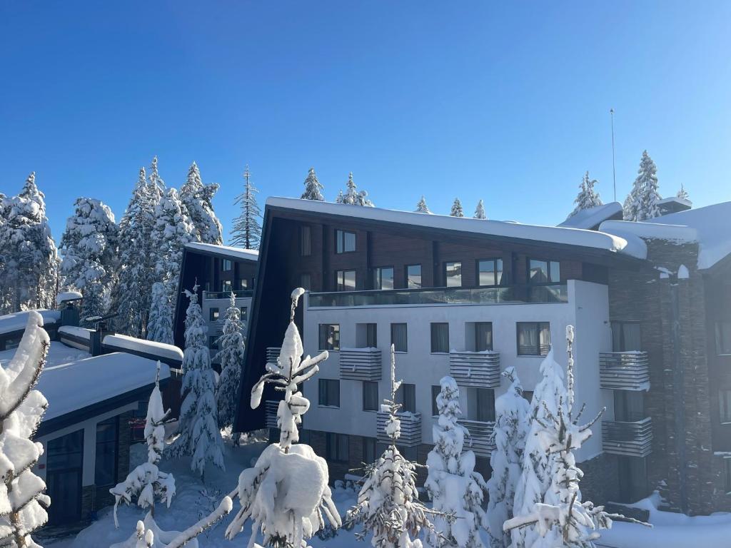a building with snow covered trees in front of it at Maisonette Mountain View - Euphoria Resort in Borovets