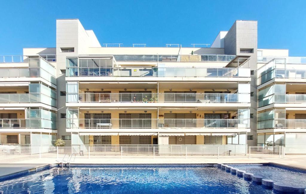 Un edificio de apartamentos con piscina enfrente. en Cozy Apartment In Moncofa, en Moncófar