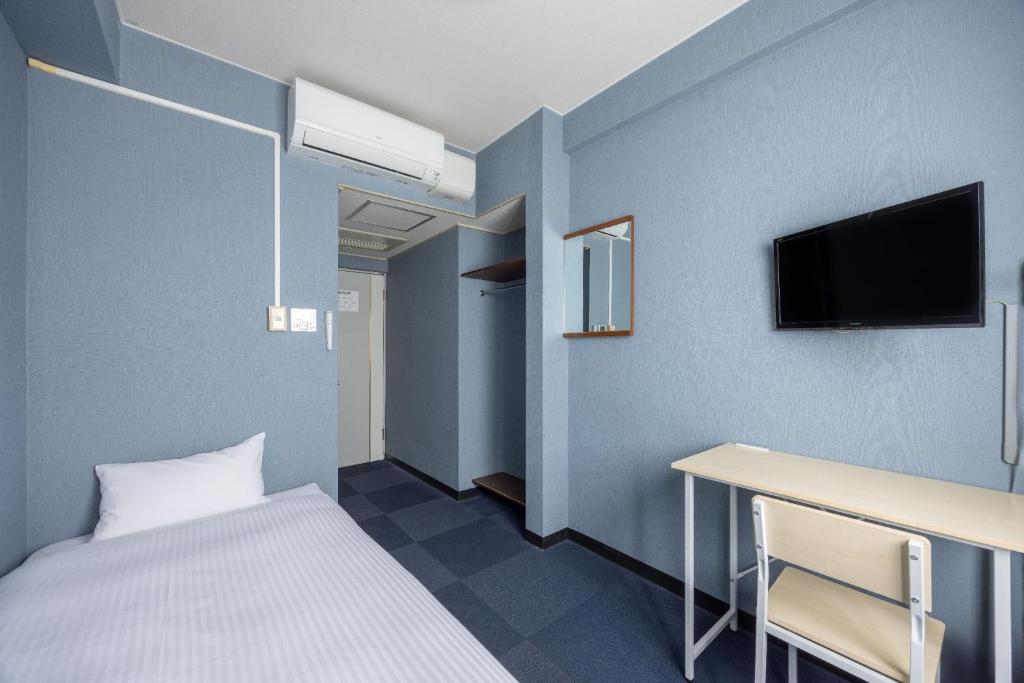 福山市にあるFukuyama Royal Hotel - Vacation STAY 46665vのベッド、デスク、テレビが備わる客室です。