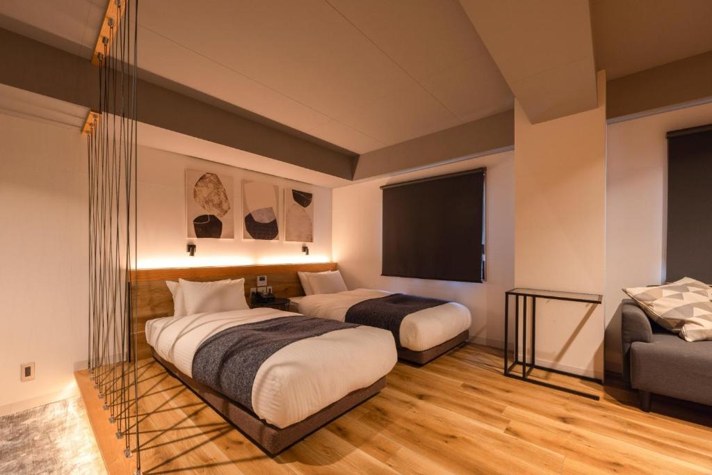 ein Hotelzimmer mit zwei Betten und einem Flachbildfernseher in der Unterkunft Fukuyama Royal Hotel - Vacation STAY 36228v in Fukuyama