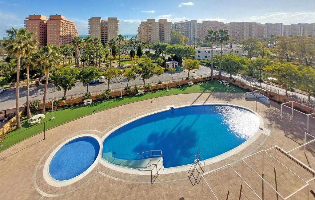 an empty swimming pool with a city in the background at Amazing Apartment In Oropesa Del Mar in Oropesa del Mar