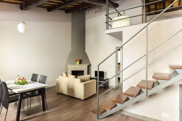 sala de estar con escalera, mesa y sofá en Navona Rubens Lodge, en Roma
