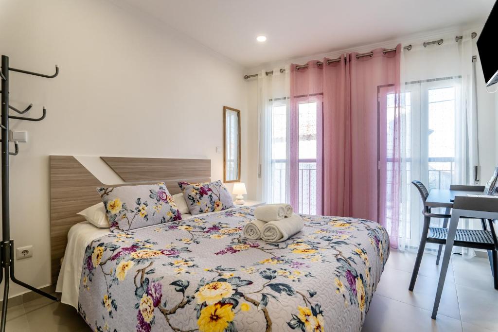 une chambre avec un lit avec un couvre-lit fleuri dans l'établissement Casa Girassol - Lagos, à Lagos