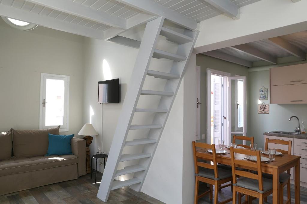 a white spiral staircase in a living room with a table at Camara Homes in Andros