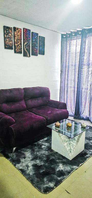 a living room with a purple couch and a table at Habitación al norte de la CDMX aeropuerto Felipe angeles in Mexico City