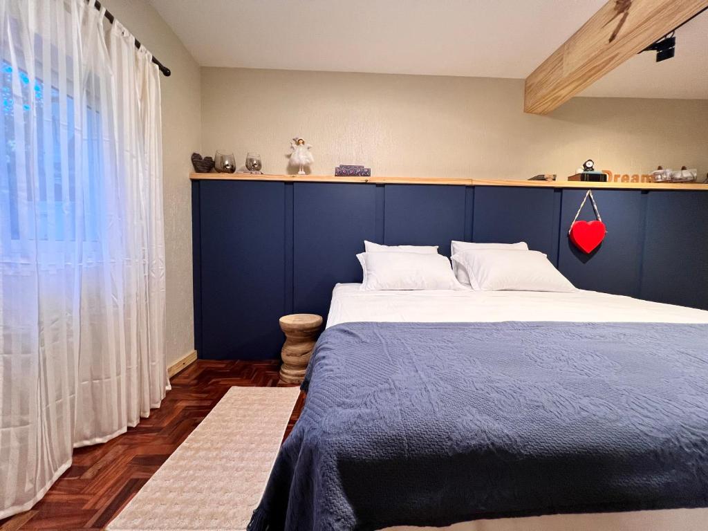a bedroom with a large bed with a blue headboard at Refúgio da Floresta N3gra in Nova Petrópolis