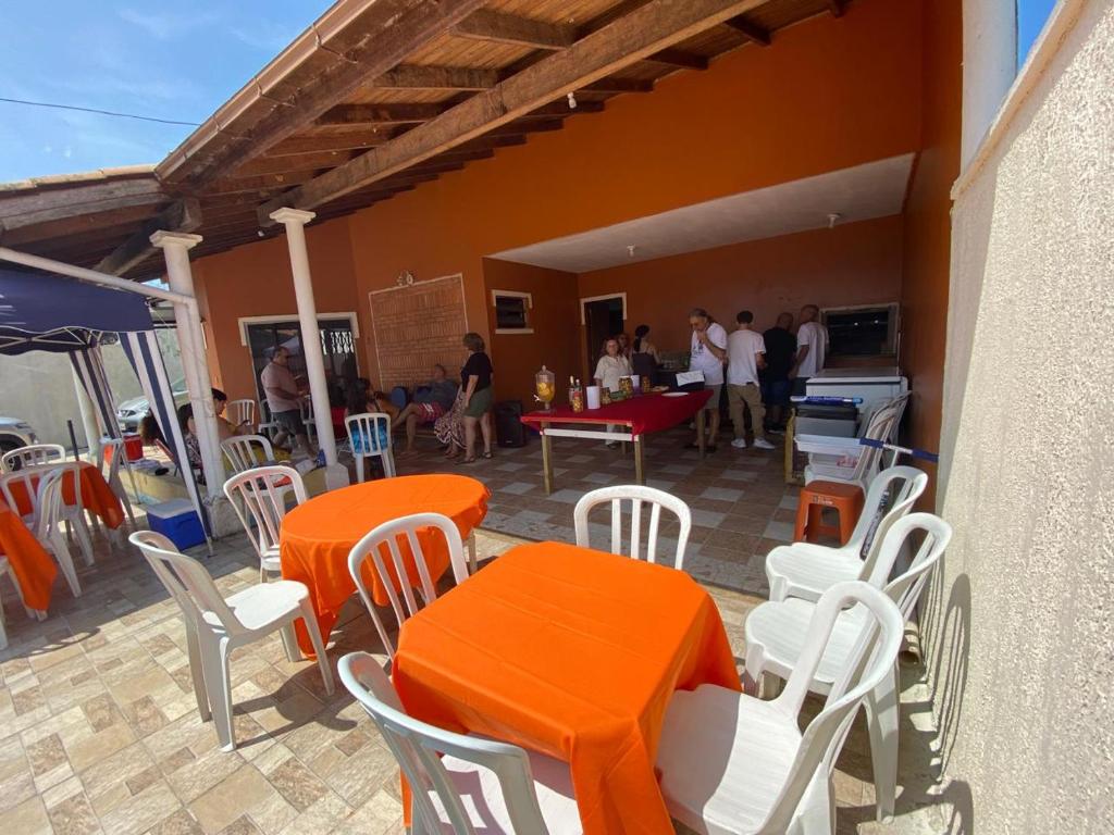 an outdoor patio with orange tables and white chairs at Imana Hostel in Florianópolis
