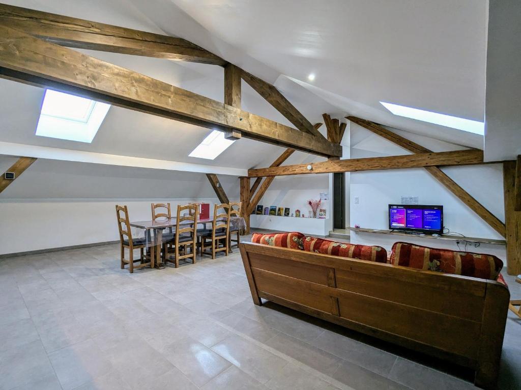 a room with a table and chairs and a tv at Appartement cosy, 2 chambres et parking privé, proche des Vosges - FR-1-589-780 in Saint-Michel-sur-Meurthe