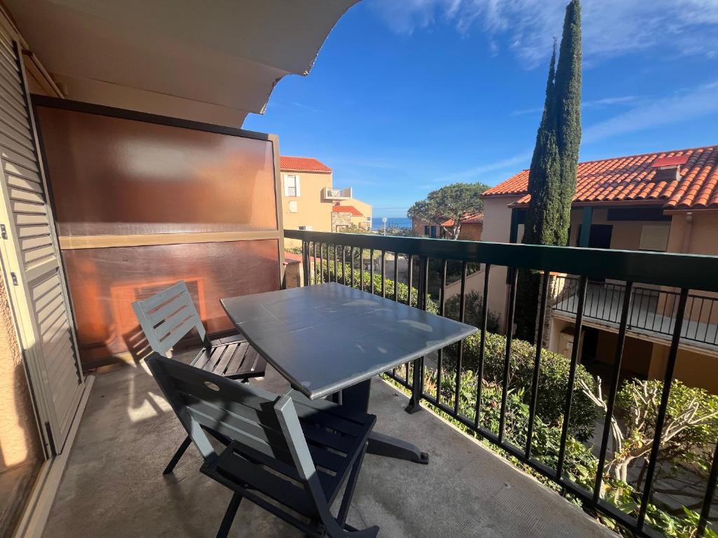un patio avec une table et des chaises sur un balcon dans l'établissement Collioure T2 élégant avec terrasse et parking - FR-1-309-492, à Collioure