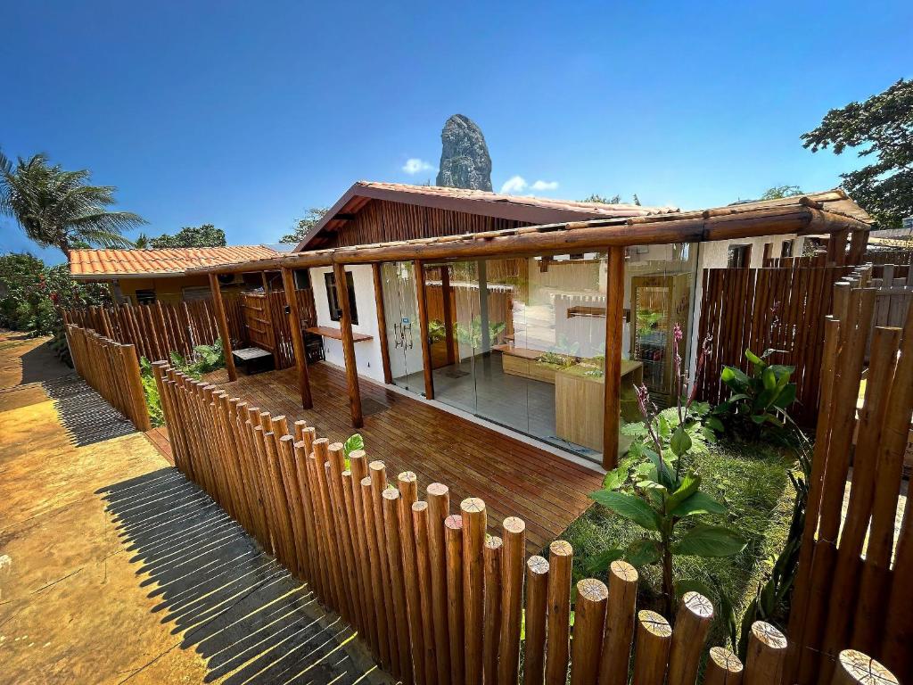 a house with a wooden fence in front of it at Noronheiro Boutique & House in Fernando de Noronha