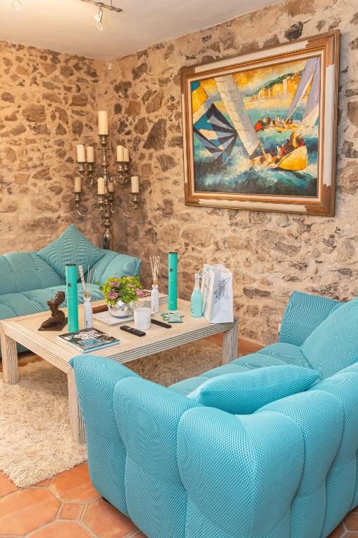 圣特罗佩Steps from the Port! Chic 2-Bed in the Heart of Saint-Tropez的客厅里有蓝色的椅子和桌子