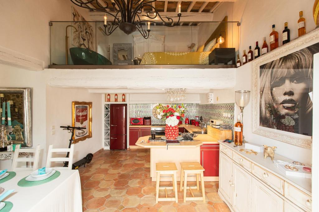 una cocina con armarios rojos y una barra con taburetes en Steps from the Port! Chic 2-Bed in the Heart of Saint-Tropez, en Saint-Tropez