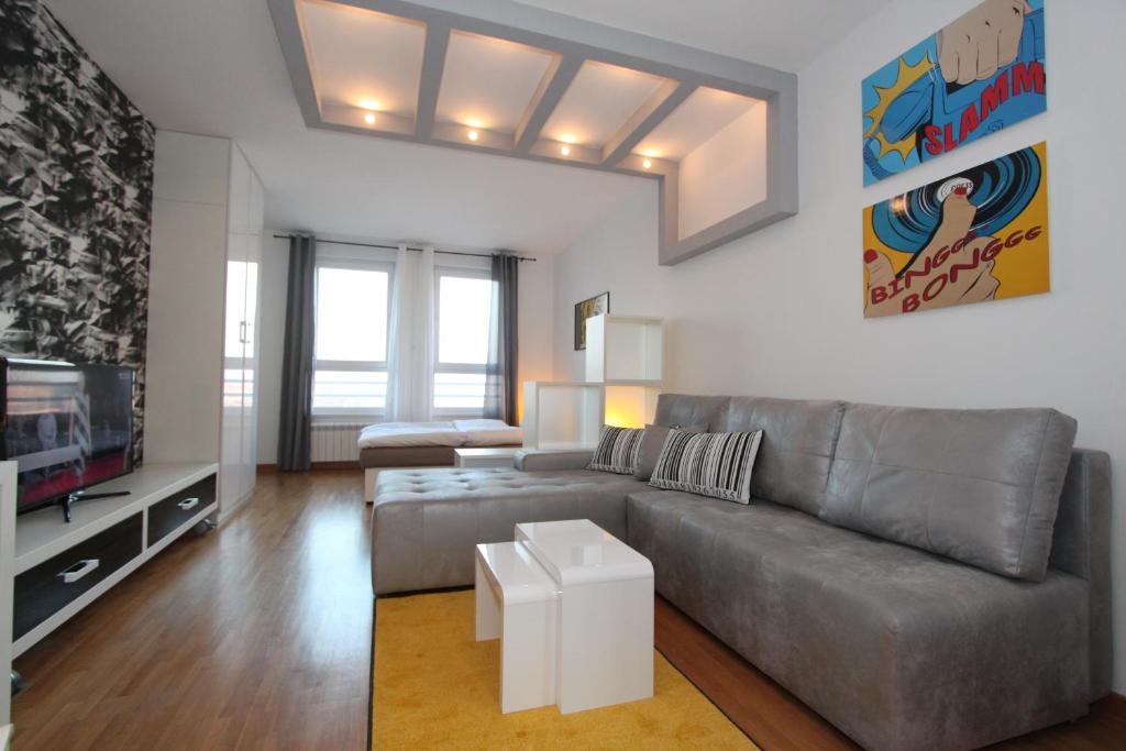 uma sala de estar com um sofá e uma televisão em New Belgrade apartment Neven, parking 5 evra dan em Belgrado