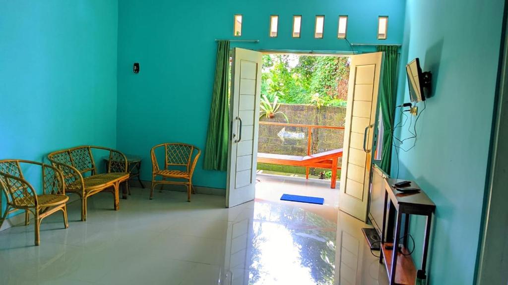 a hallway with chairs and a door to a patio at Wisma KLG 1 in Kaliurang