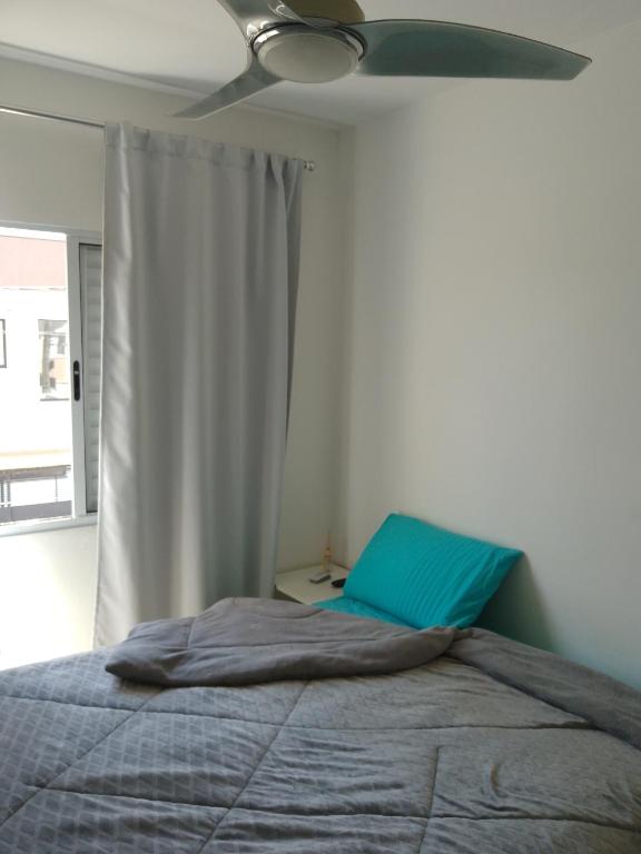 a bedroom with a bed and a ceiling fan at Ap no centro do Vila Branca in Jacareí