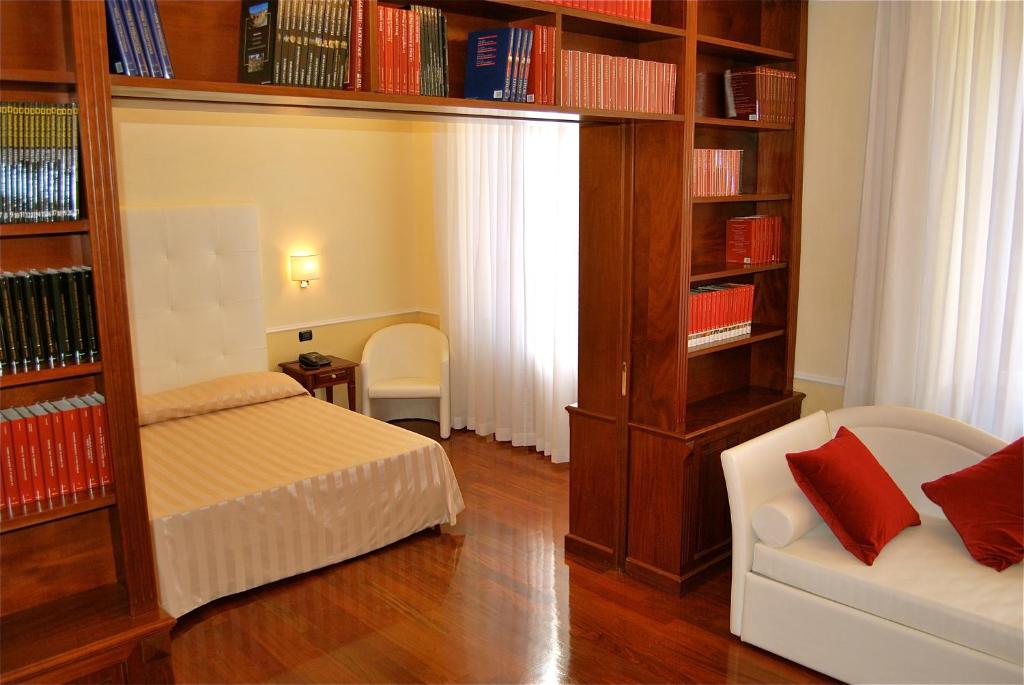 a bedroom with a bed and book shelves with books at Ludovisi Luxury Rooms in Rome