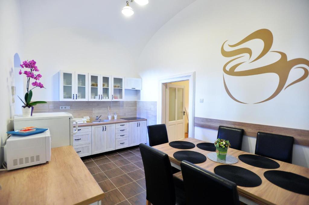 a kitchen with a dining room table and chairs at Főtér Apartman in Eger