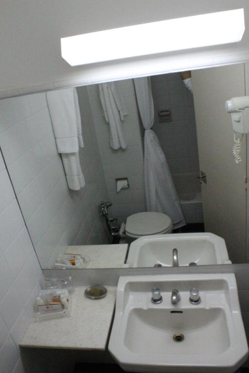 a bathroom with a white sink and a mirror at Comodoro Hotel in Comodoro Rivadavia