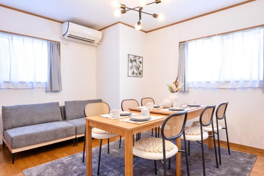 ein Wohnzimmer mit Tisch und Stühlen und einer Couch in der Unterkunft OSAKA COZY HOUSE For Family & Group 2bedroom in Takaishi