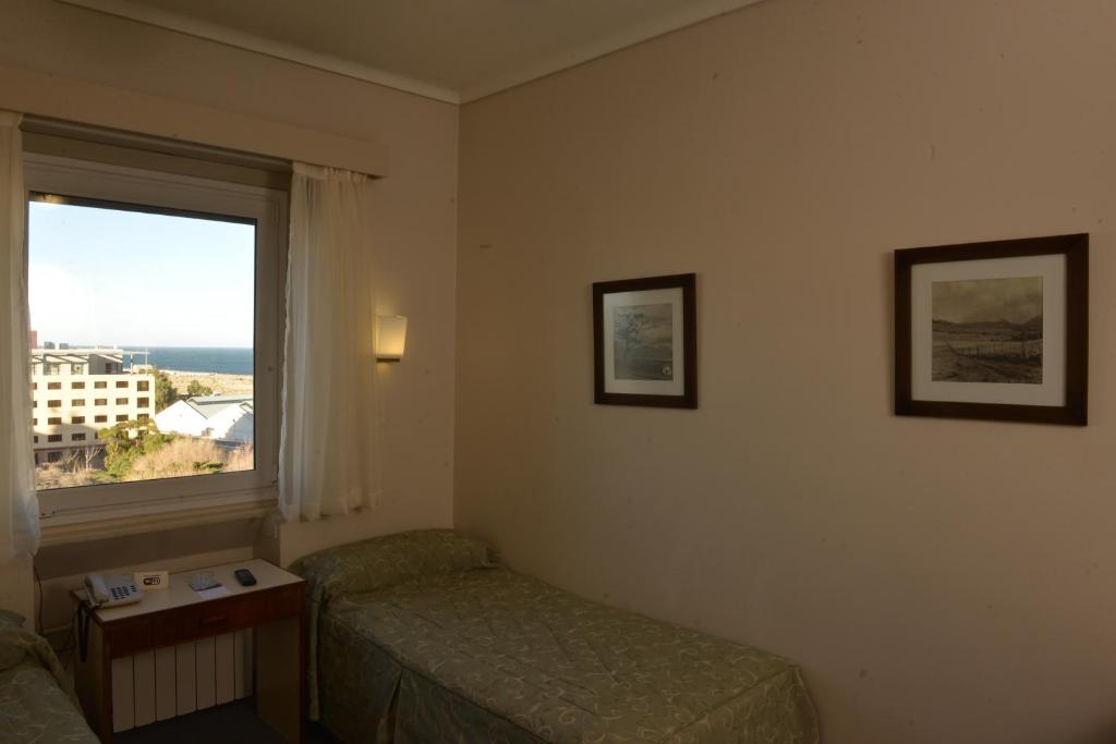 a hotel room with a bed and a window at Comodoro Hotel in Comodoro Rivadavia