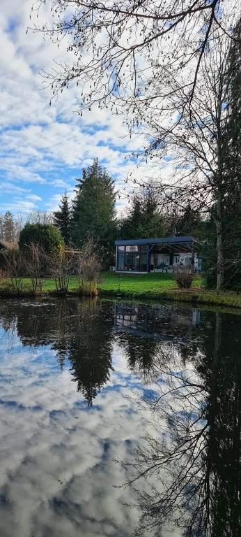 une maison assise à côté d'une nappe d'eau dans l'établissement La heckeliere, à La Houssière
