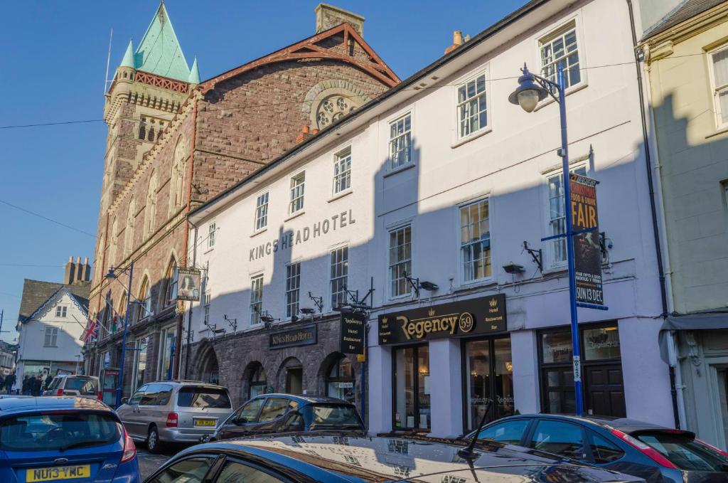 ulica z samochodami zaparkowanymi przed budynkami w obiekcie The Kings Head Hotel w mieście Abergavenny