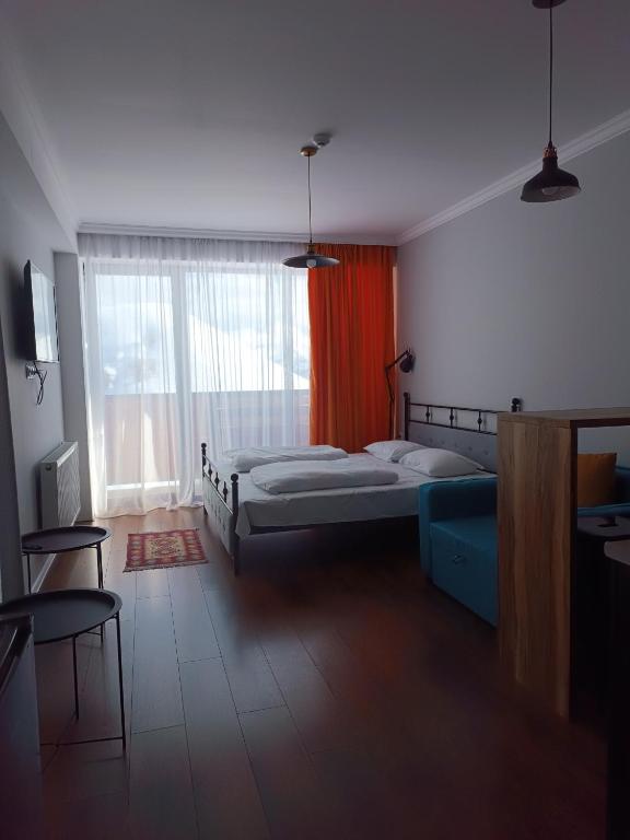 a bedroom with two beds and a large window at Twins studio N339 in Gudauri