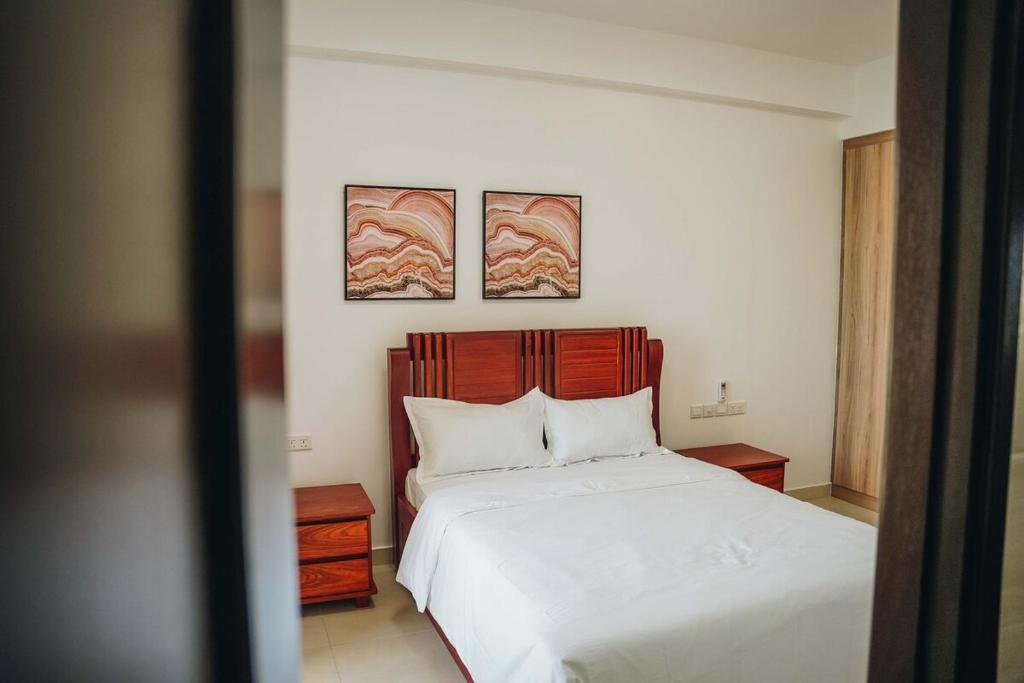 a bedroom with a bed with two pictures on the wall at Elles Residence - Serenity in Dar es Salaam