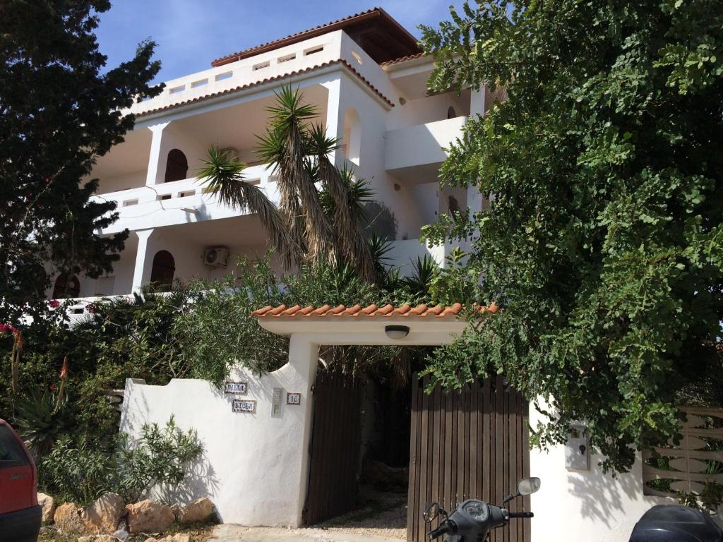 una casa blanca con una palmera delante de ella en Villa Dacla en Lampedusa