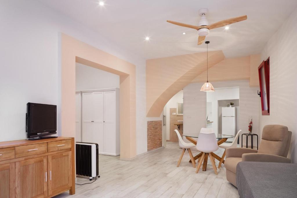 a living room with a couch and a tv and a table at Loft con encanto en el corazón histórico de Peralada in Peralada