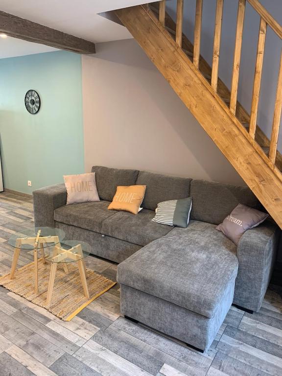 un salon avec un canapé et un escalier dans l'établissement CHEZ GRANDMA GEO location in Chablis, à Chablis