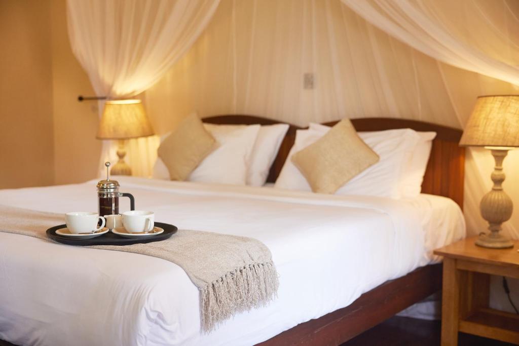 a bedroom with a bed with two cups and a tray at Aero Club of East Africa in Nairobi