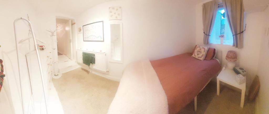 a small bedroom with a bed and a window at Centrel to london single bed room quiet home with host and breakfast in London