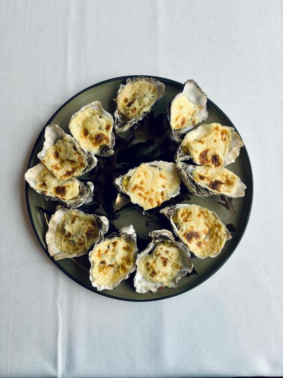 a plate of oysters sitting on a table at La Cremaillere Hôtel-Restaurant in Courseulles-sur-Mer