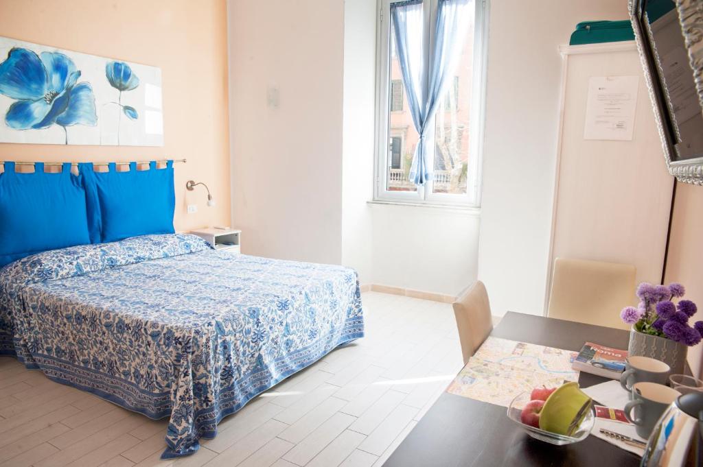 ローマにあるメルラーナ スイートのベッドルーム1室(青いベッドカバー付)