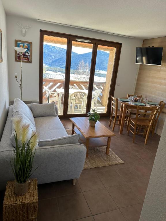 un salon avec un canapé et une table dans l'établissement Appart T2 Cosy vue panoramique Lac & Montagnes, aux Angles