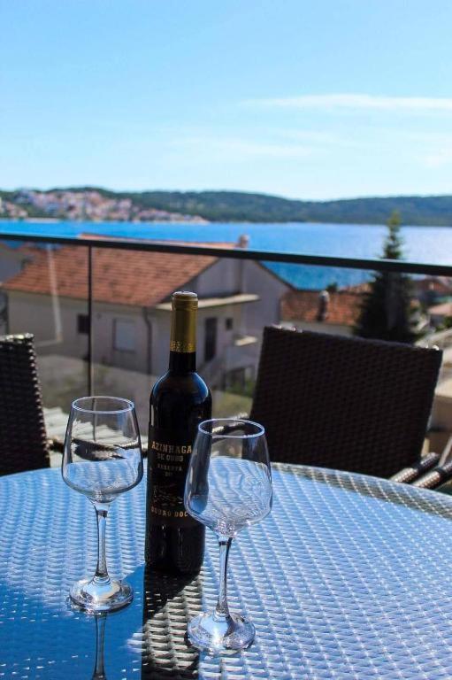 butelkę wina i dwa kieliszki wina na stole w obiekcie Apartmani Manuela w Okrugu Gornjim