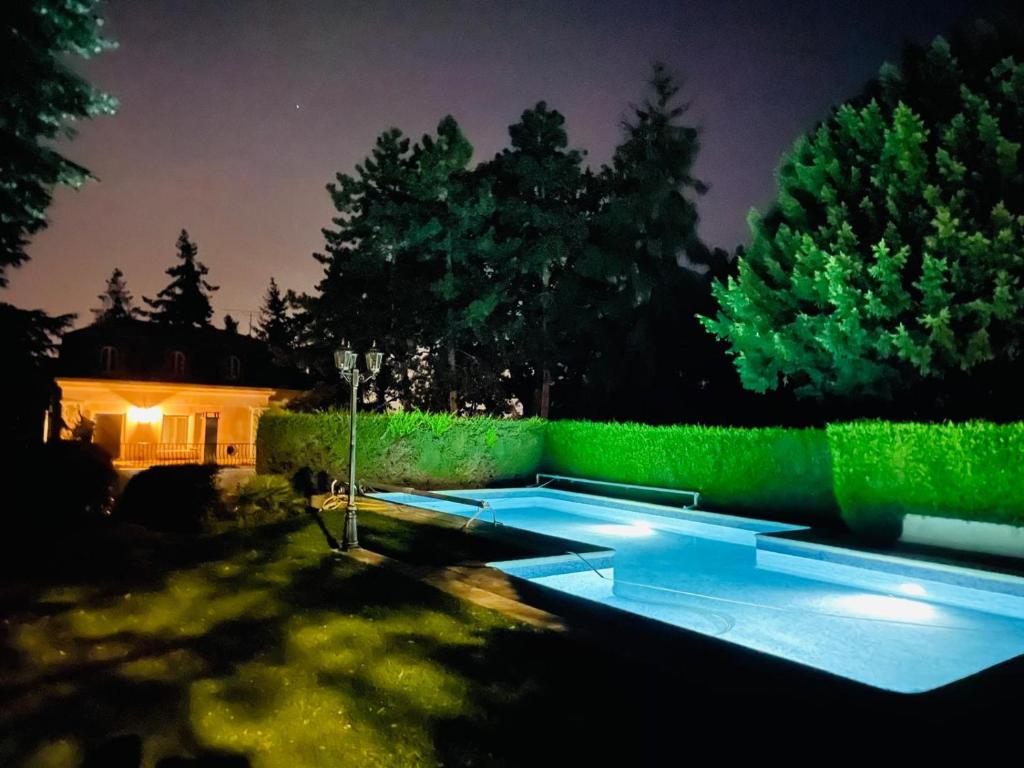 a backyard with a swimming pool at night at Hôtel Le domaine de Montmorency in Montmorency