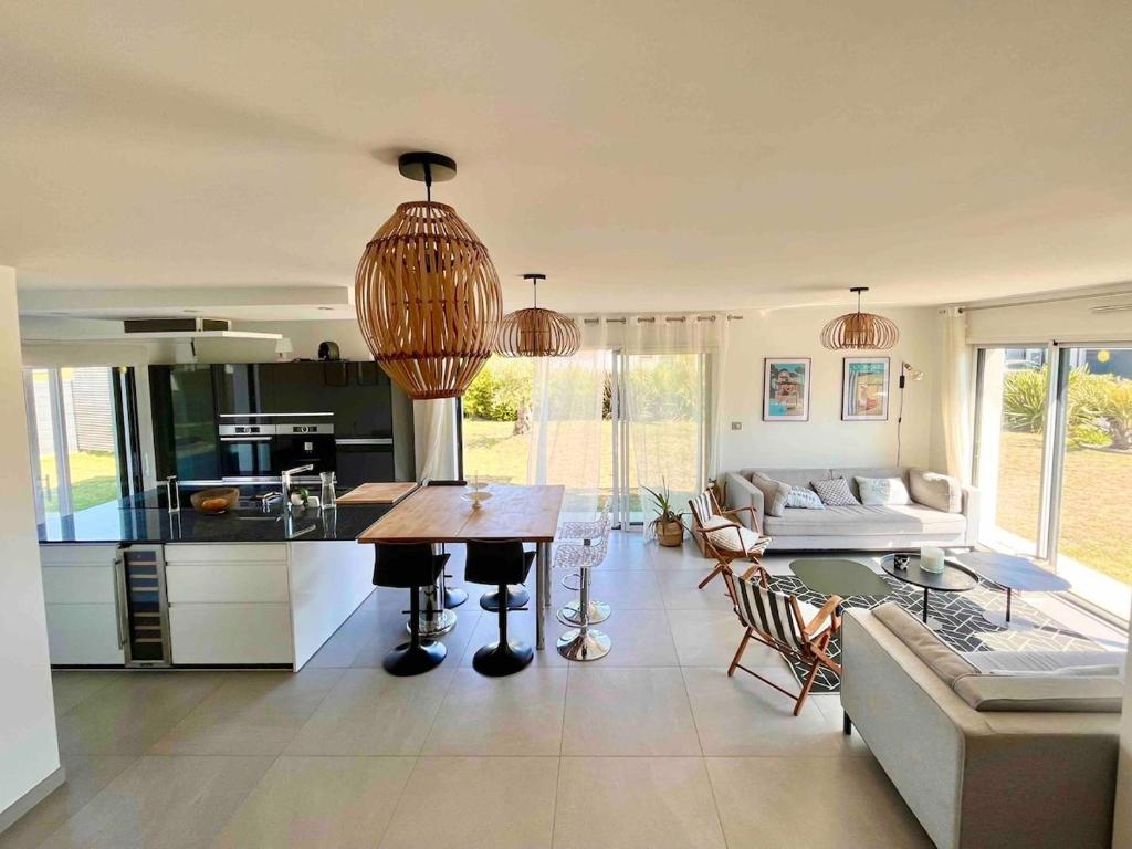 une cuisine et un salon avec une table et un canapé dans l'établissement Beautiful new house near beach and train station, à La Baule