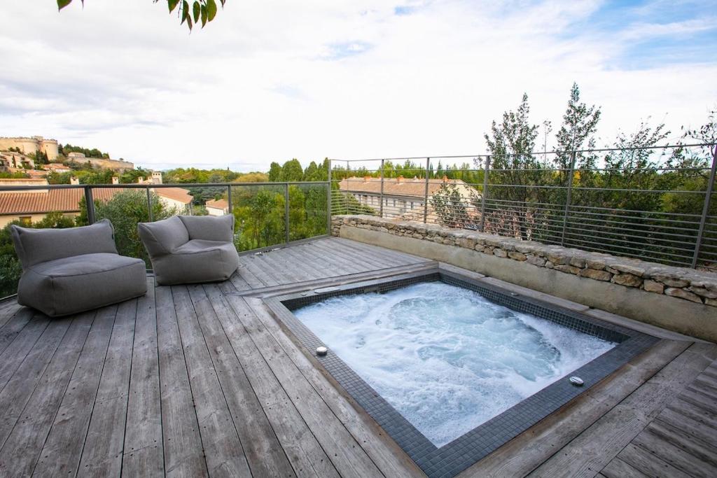 - un bain à remous sur une terrasse avec 2 chaises dans l'établissement Cocon luxe vue balcon sauna jacuzzi piscine, à Villeneuve-lès-Avignon