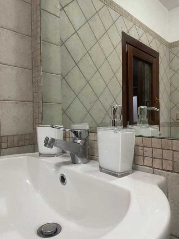 a bathroom with a white sink with a mirror at Casa Vacanza Betty in Partanna