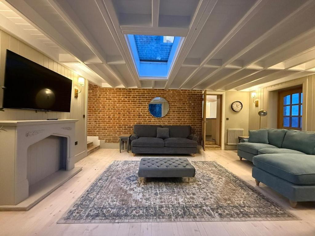 a living room with a couch and a tv at Rose Cottage, Luxury cottage, sleeps 16 in South Raynham